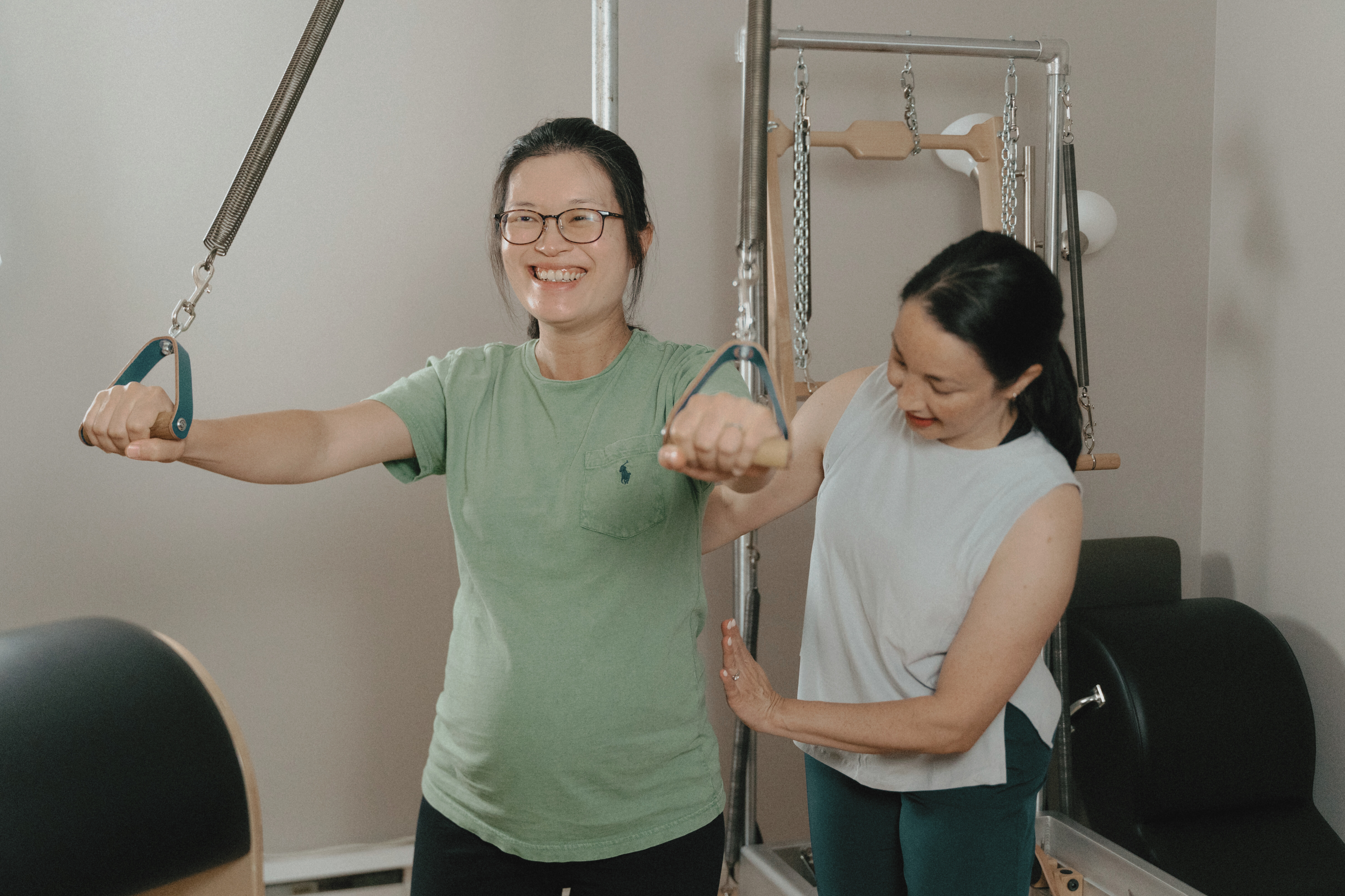 Une cliente enceinte profite d'un exercice de renforcement des bras avec l'appareil de Pilates classique, le Pedipul.